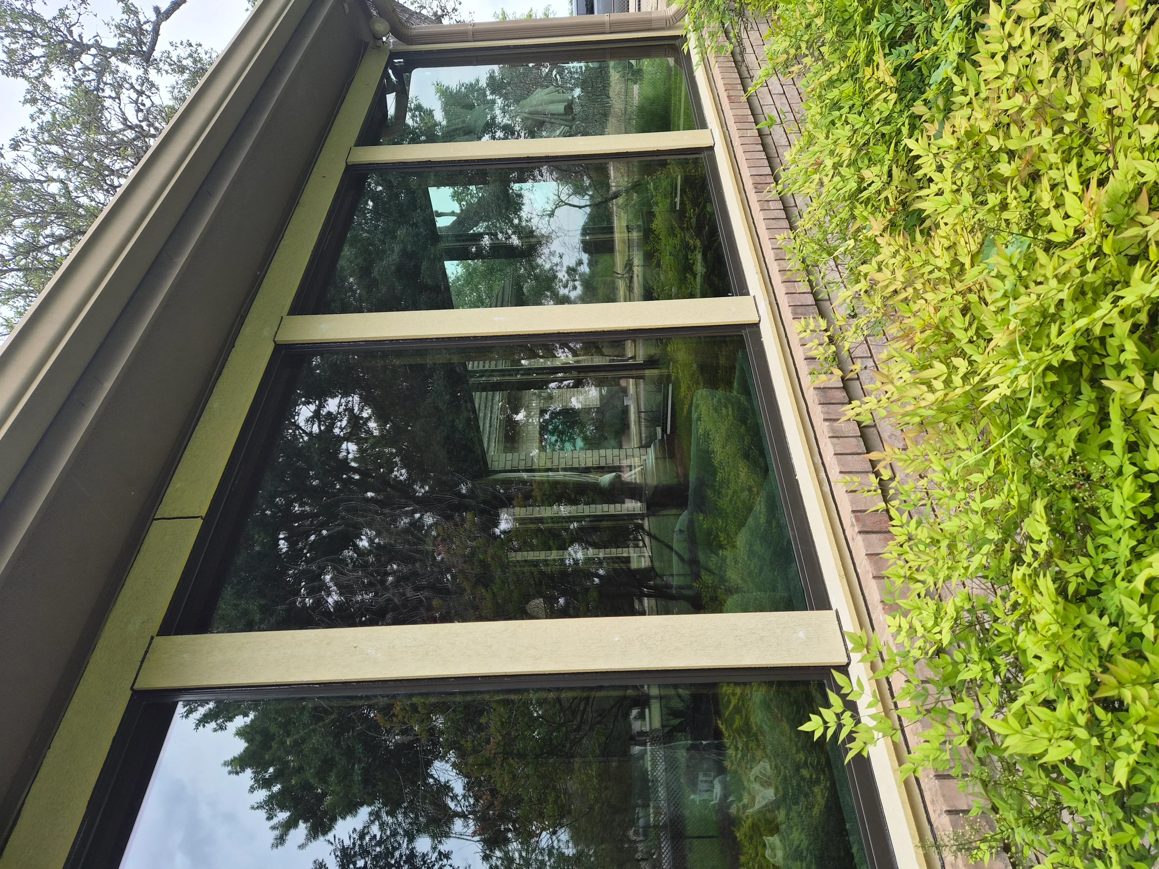Four-pane modern window with aluminum frame installed on brick home exterior