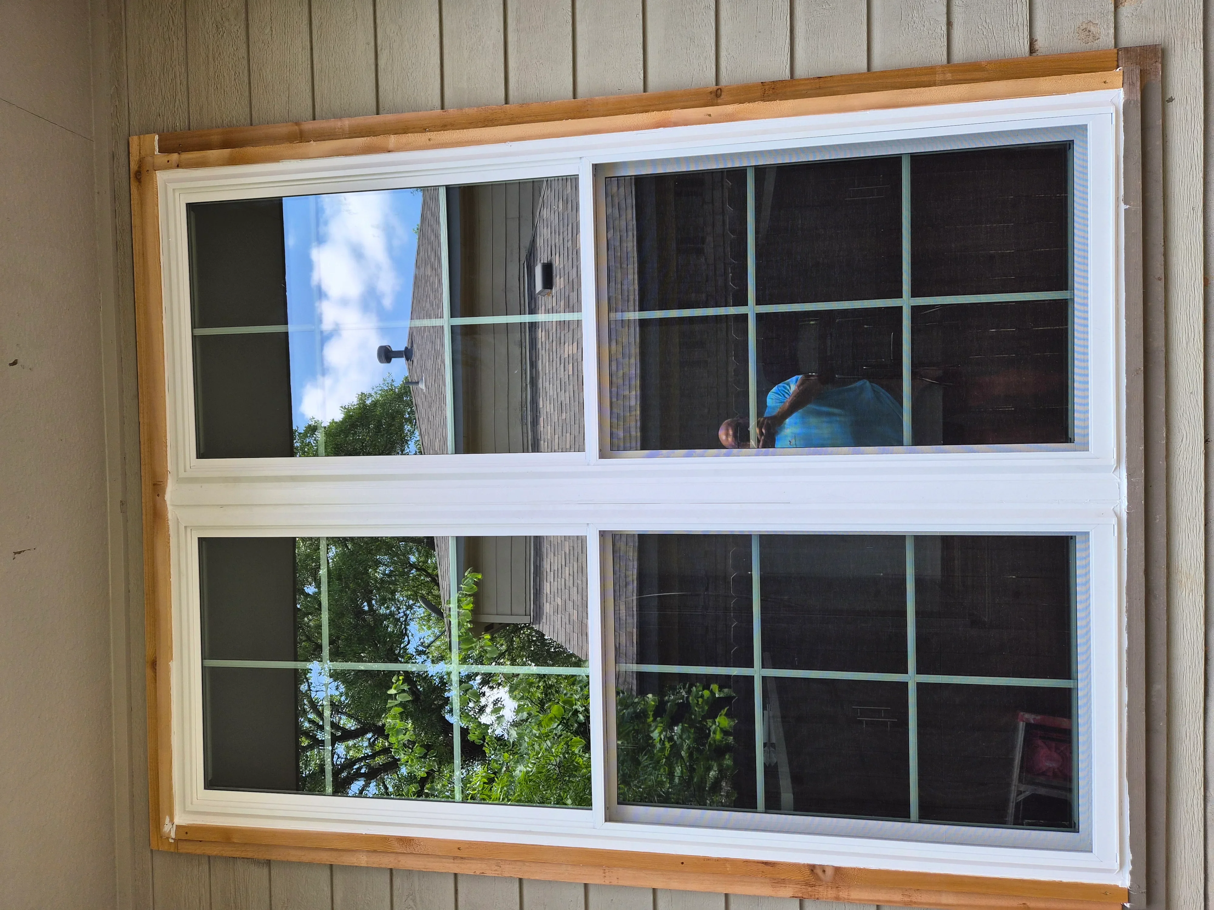 White vinyl multi-pane window with grid muntins installed on wood siding exterior